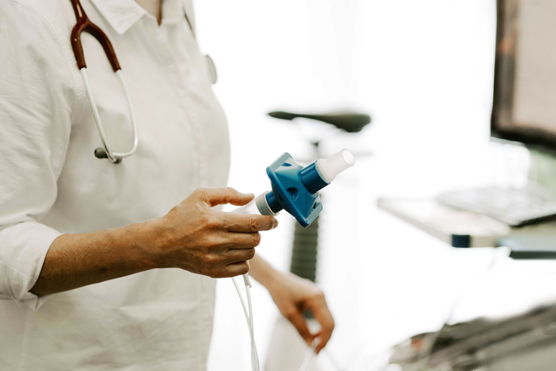 Eine Praxismitarbeiterin hält ein Spirometrie-Gerät in der Hand